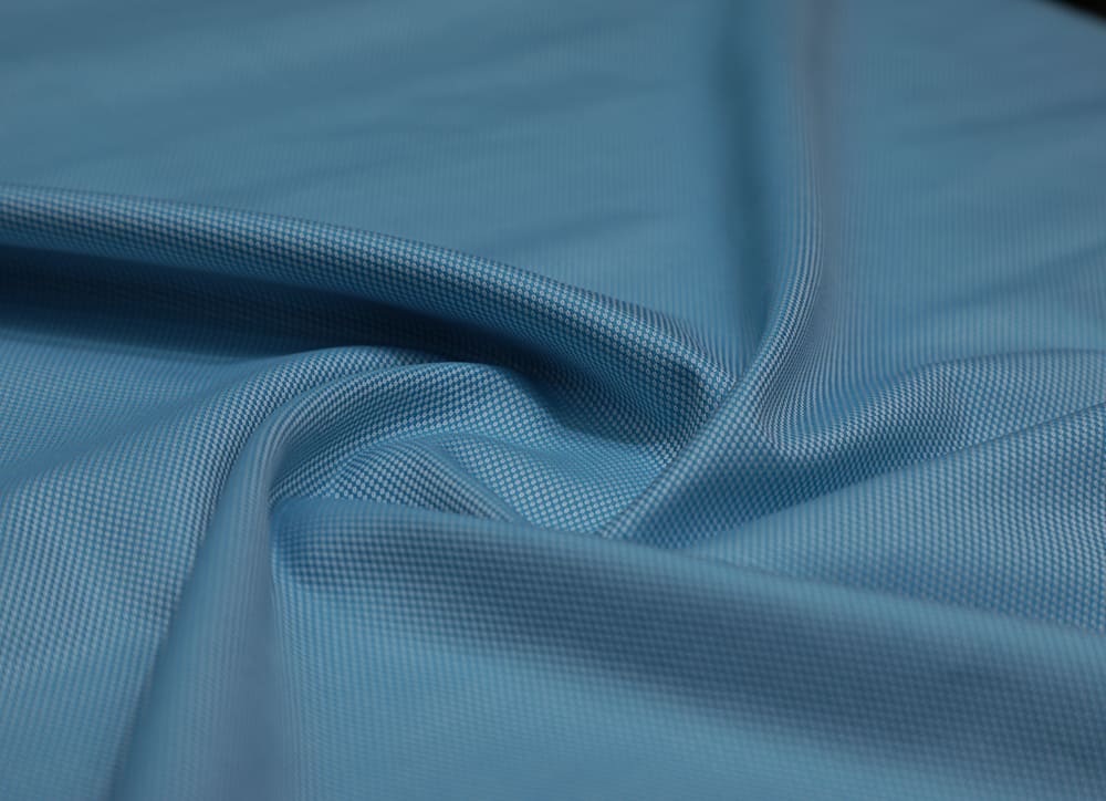 This is a close look at a piece of blue Poly Cotton fabric.