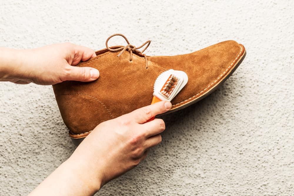 This is a close look at a man cleaning his Suede brown shoes.