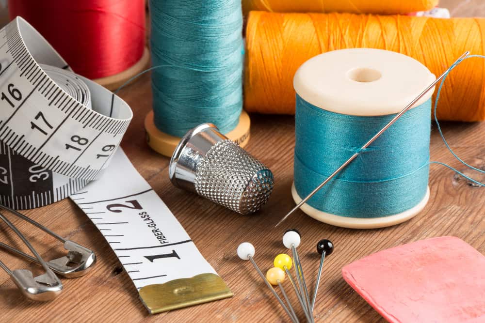 This is a close look at various sewing essentials on a wooden table.