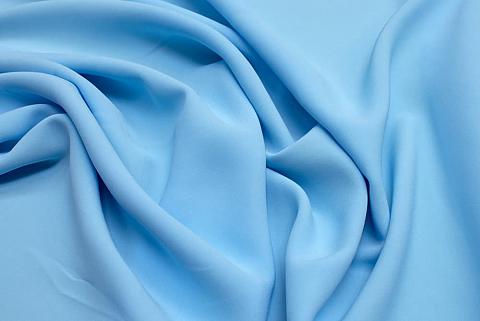This is a close look at a piece of blue wrinkled rayon fabric.