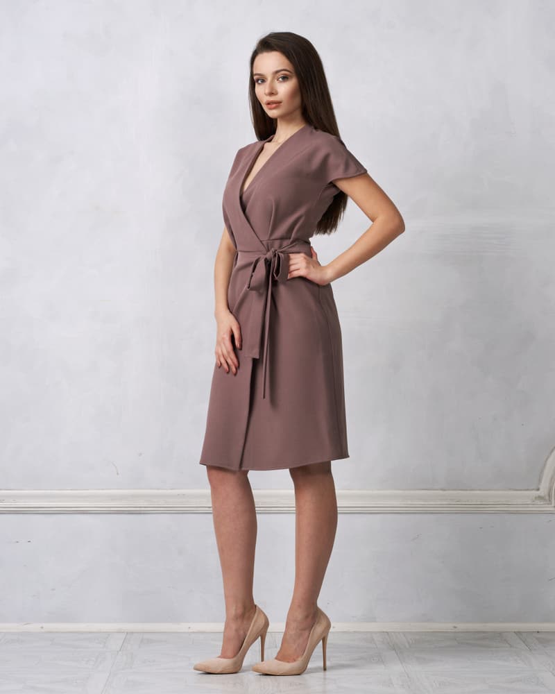 A woman wearing a brown Wrap Dress paired with heels.
