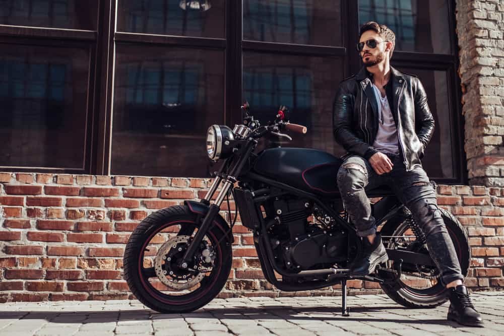 Bearded man in leather jacket sitting on his bike.