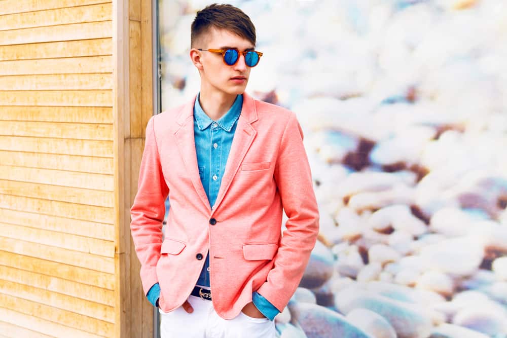Portrait of a young man wearing shades and trendy bright clothes.