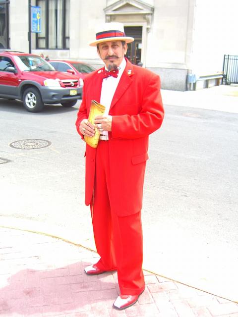 A man wearing a zoot suit with hat and leather shoes.