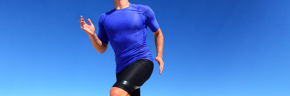 This is a close look at a man running wearing a pair of black compression shorts.