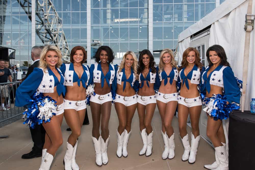 This is a close look at a group of cheerleaders wearing cowboy boots and soffe shorts.