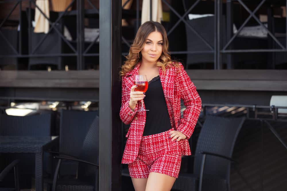 A woman wearing matching red shorts and blazer.