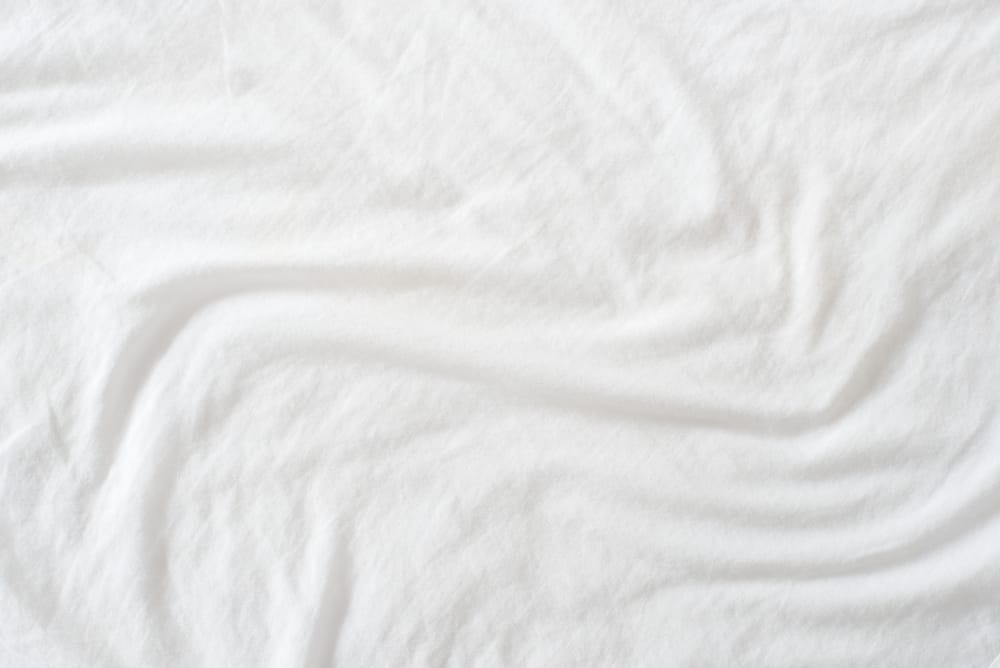 This is a close look at a white crumpled bed sheet.