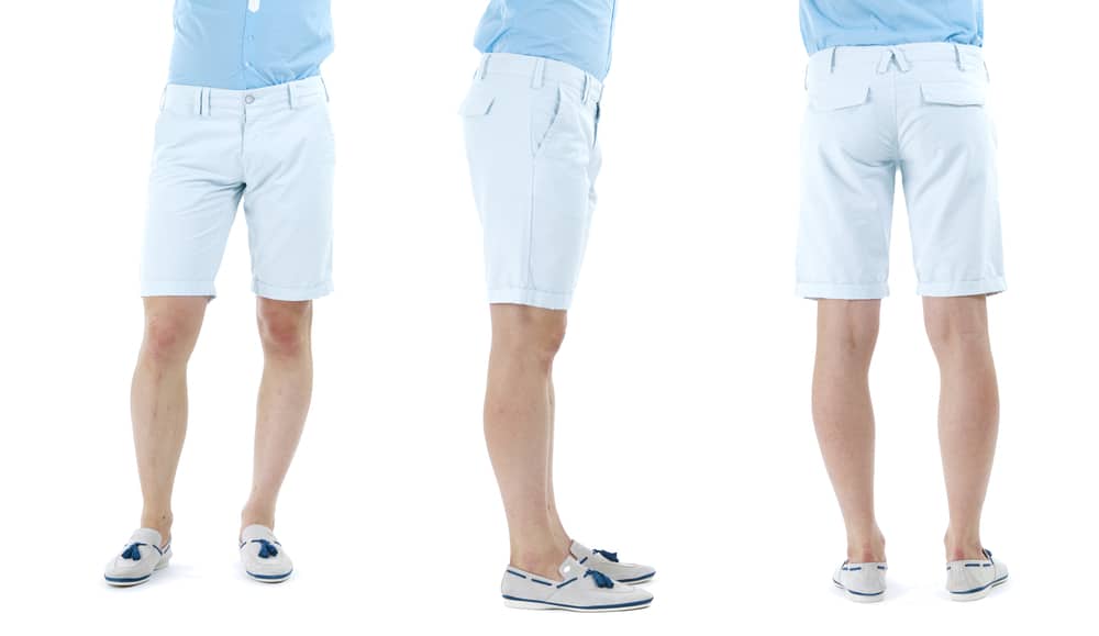 This is a close look at a man wearing a pair of blue tailored shorts and moccasins.