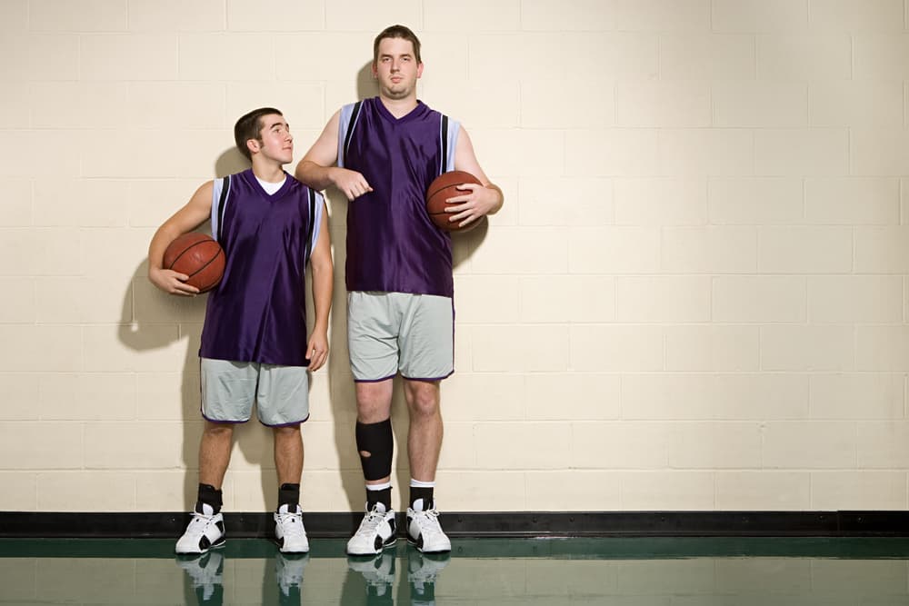 A close look at two men wearing basketball uniforms.