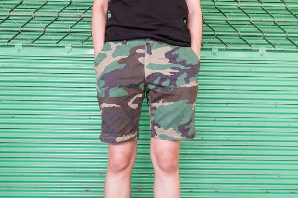 This is a close look at a man wearing a pair of printed camouflage shorts.