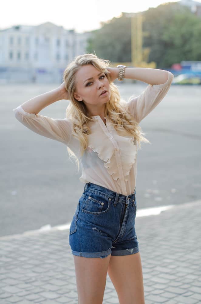 A woman wearing a pair of denim high-waisted shorts.