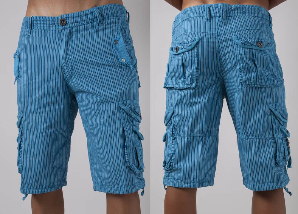 This is a close look at a man wearing a pair of long striped cargo shorts.