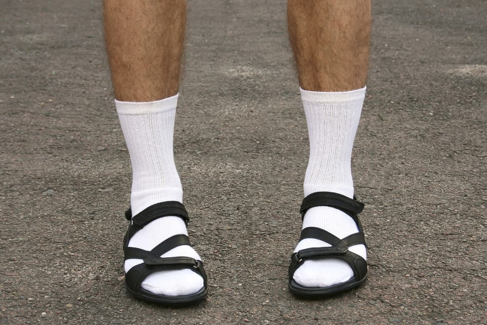 A close look at a man wearing socks and sandals.