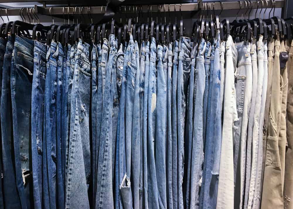 A close look at a pants rack display at a store with jeans and khakis.
