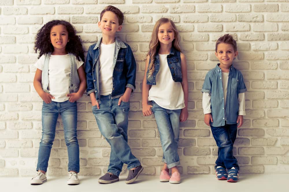 A row of kids wearing jeans.