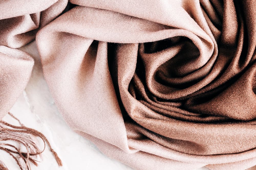 This is a close look at a beige cashmere scarf.