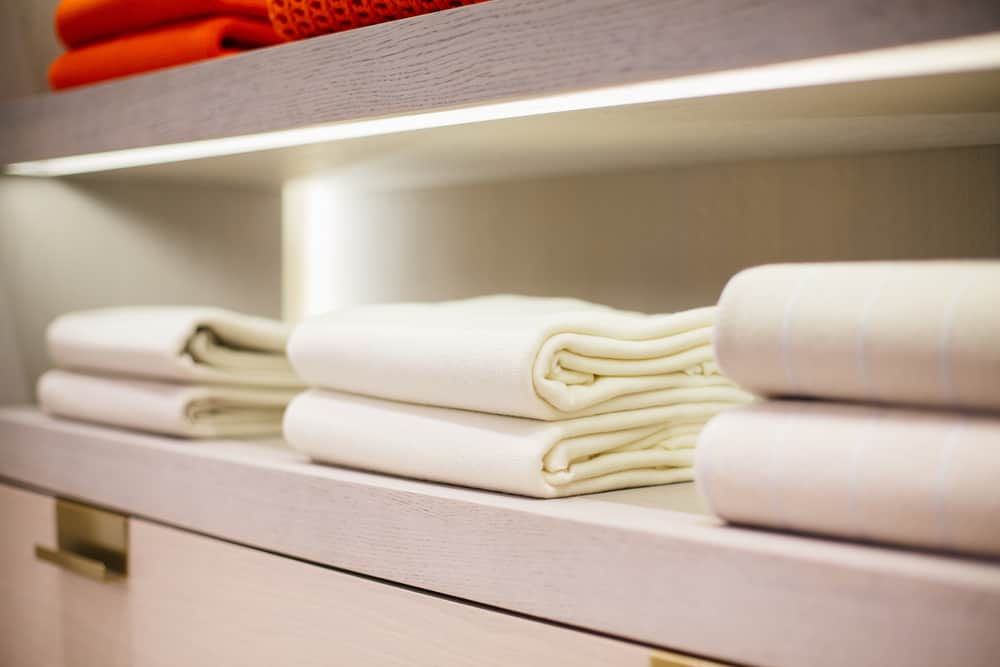 A close look at multiple folded cashmere clothes in open shelves.