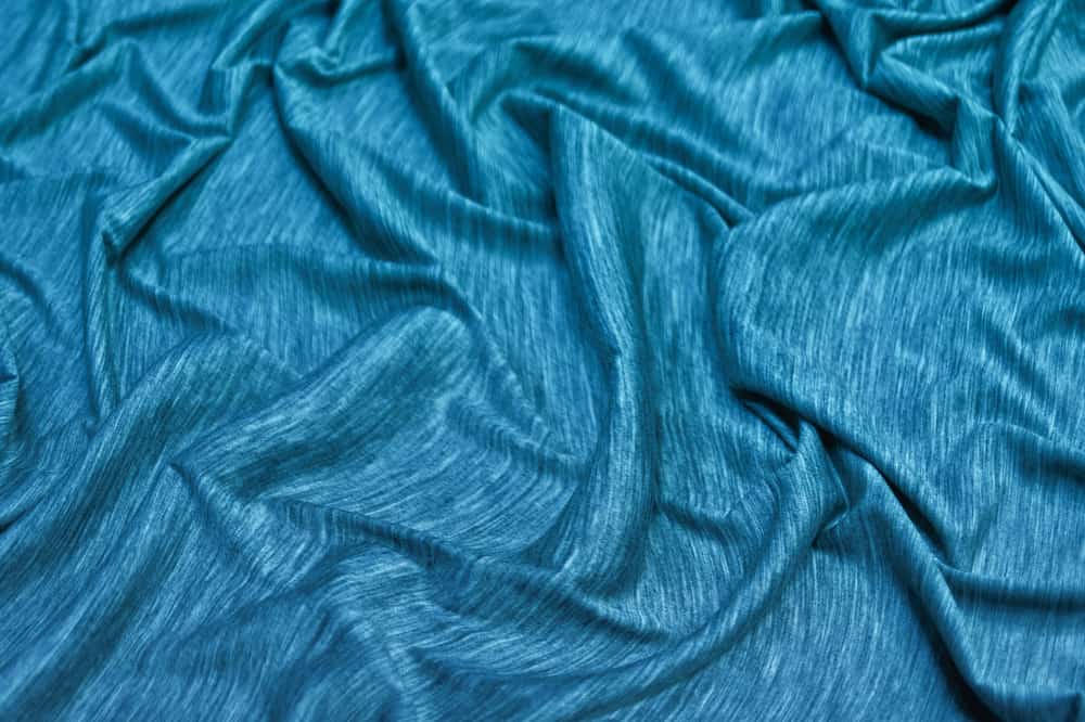 This is a close look at a piece of blue-green silk jersey.
