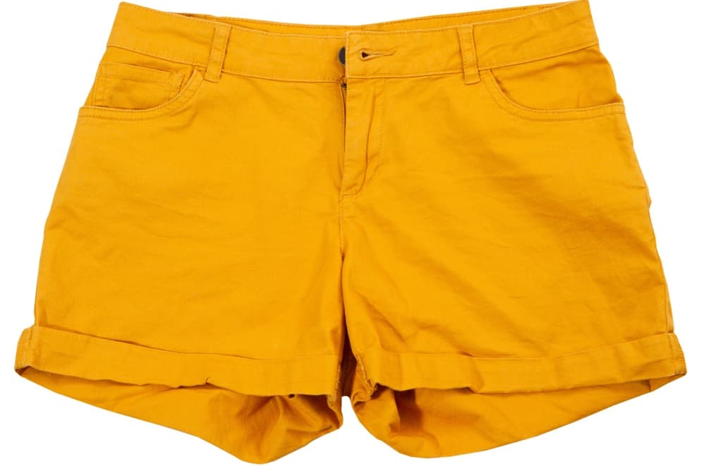 This is a close look at a pair of mustard yellow shorts with cuffs.
