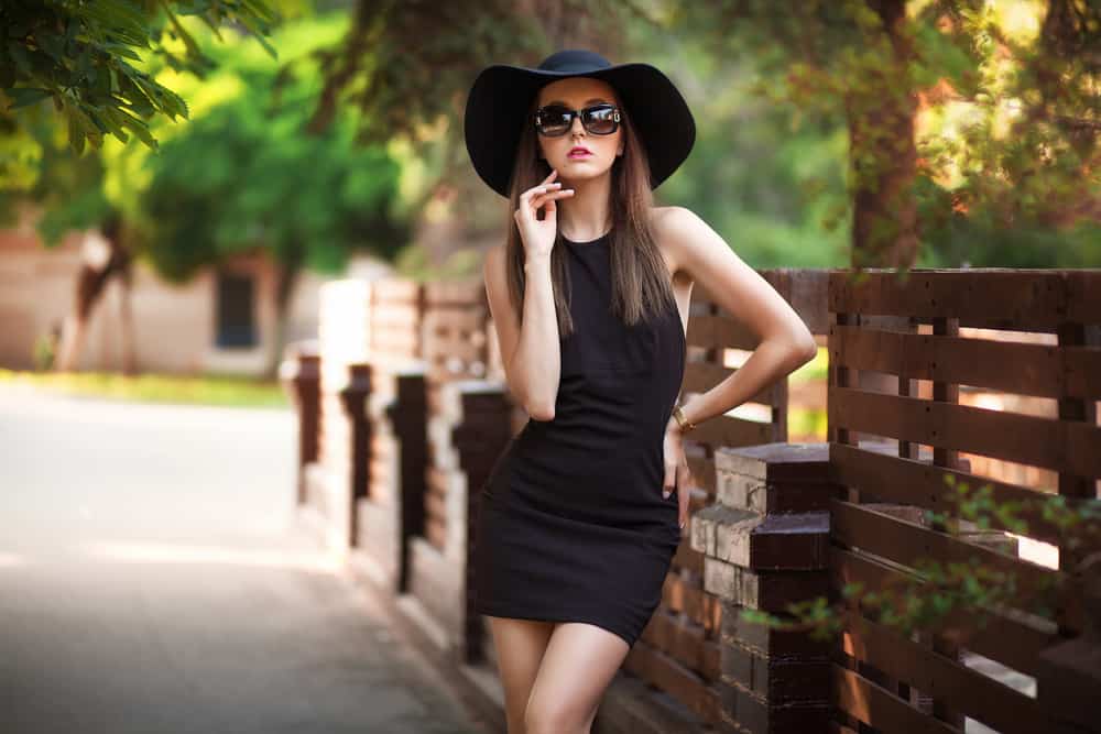 A woman wearing a little black dress at the park.