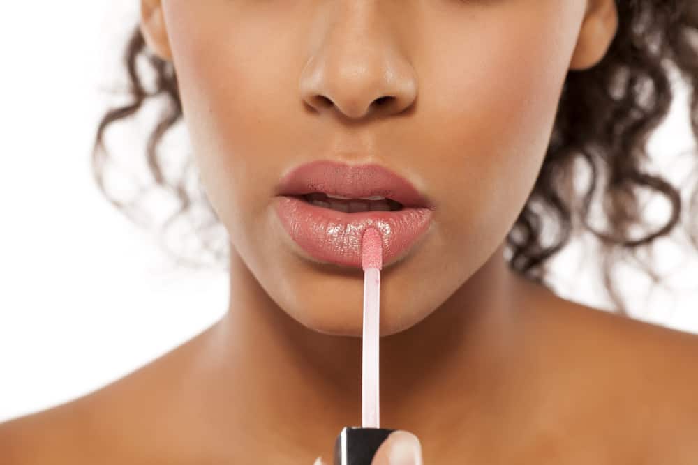Woman applying lip gloss.