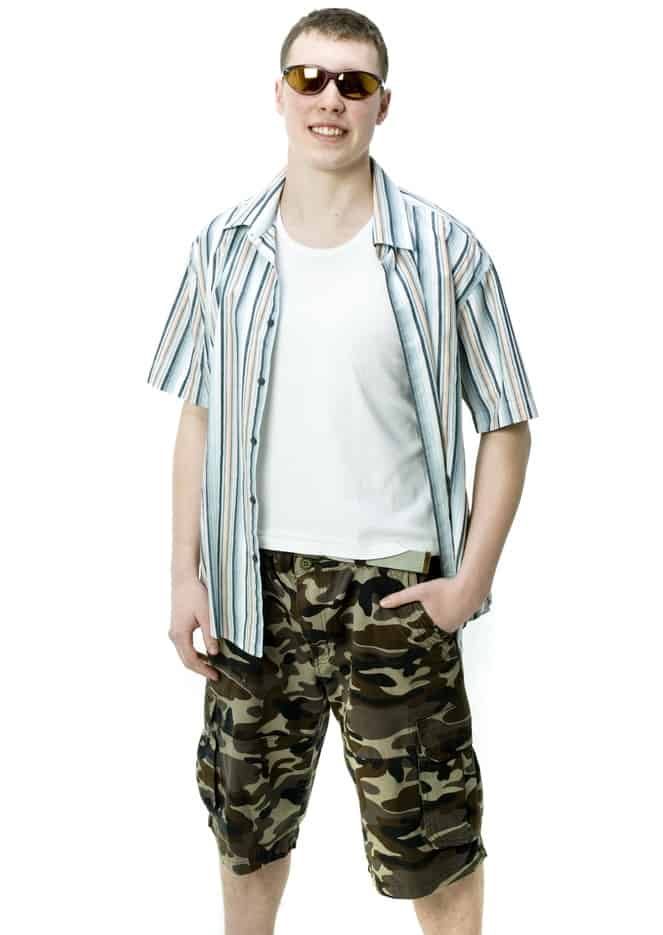 This is a man wearing a white shirt with his camo shorts.