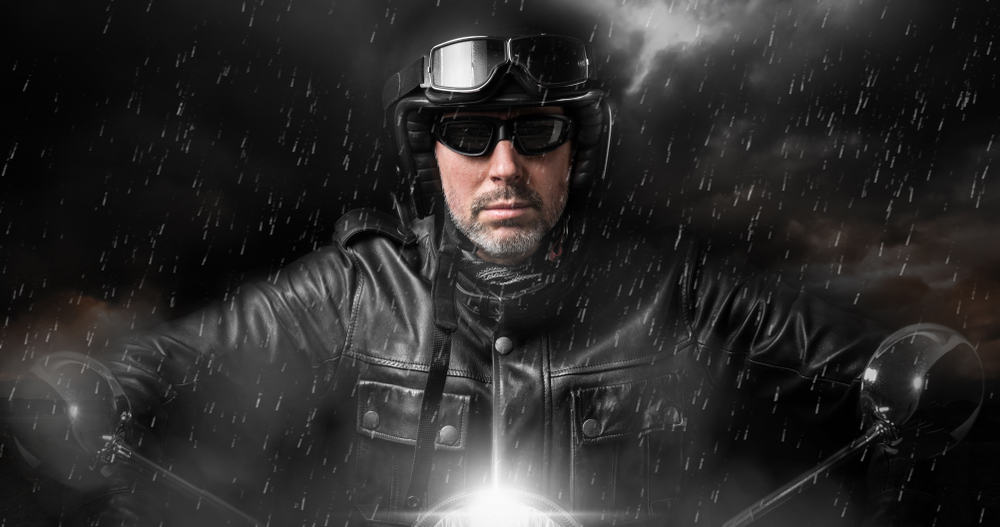 This is a close look at a biker riding in the rain.