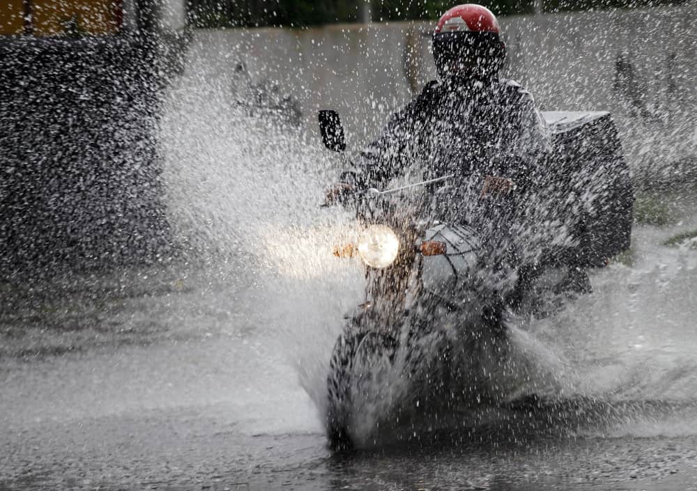 This is a motorcycle delivery worker in the rain.