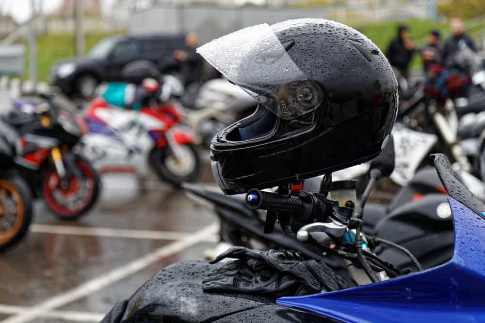 This is a close look at a wet black motorcycle helmet.