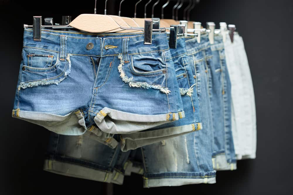 A row of shorts on a rack display at a store.