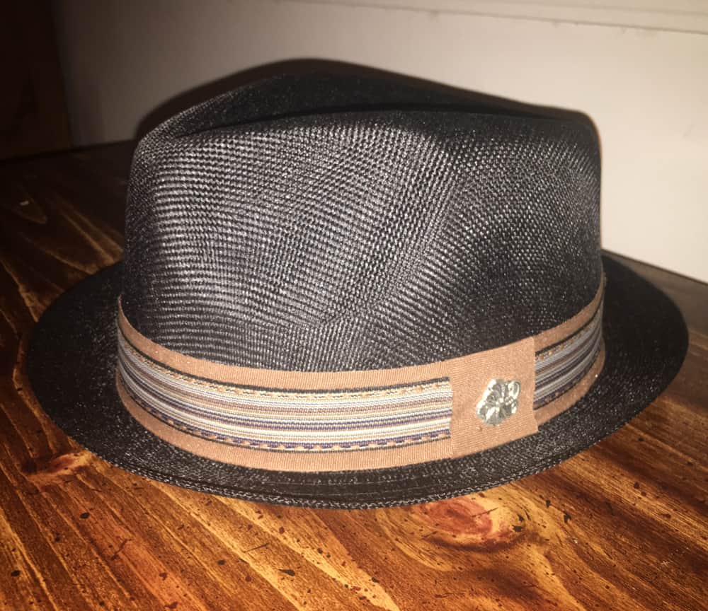 This is a close look at a pork pie hat on a table.