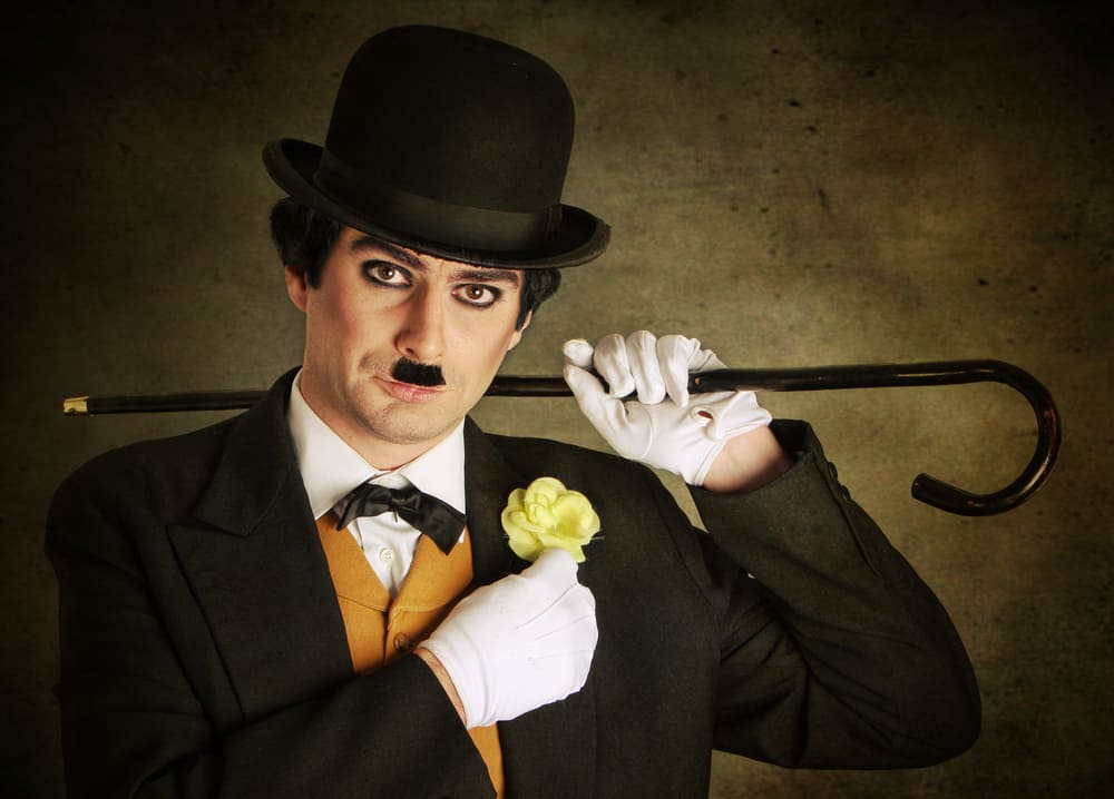 This is a close look at a man dressed as Charlie Chaplin.