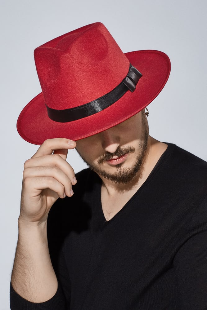 A man wearing a black shirt and red fedora.