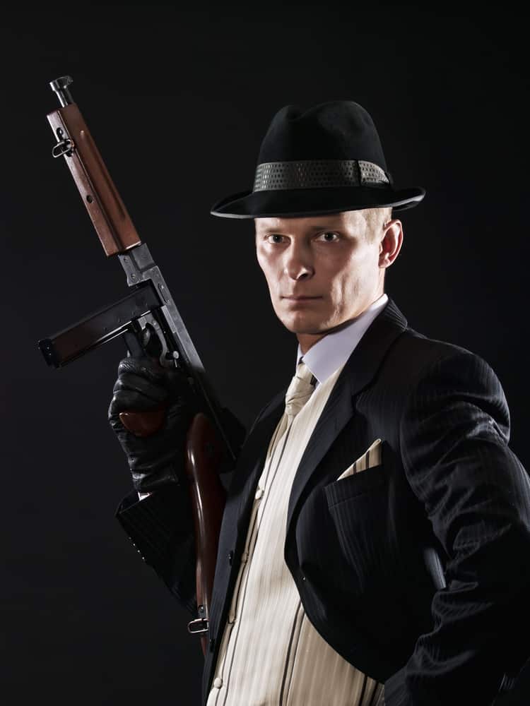 A man in a gangster costume with a fedora.