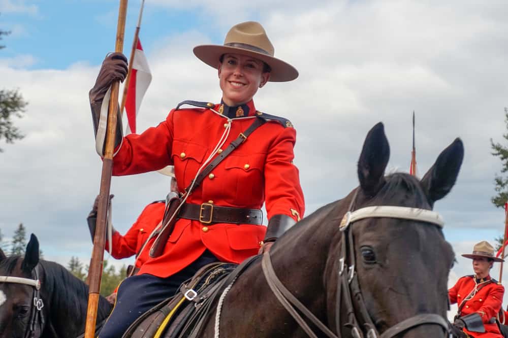 A Canadian Ranger atop a large brown horse.