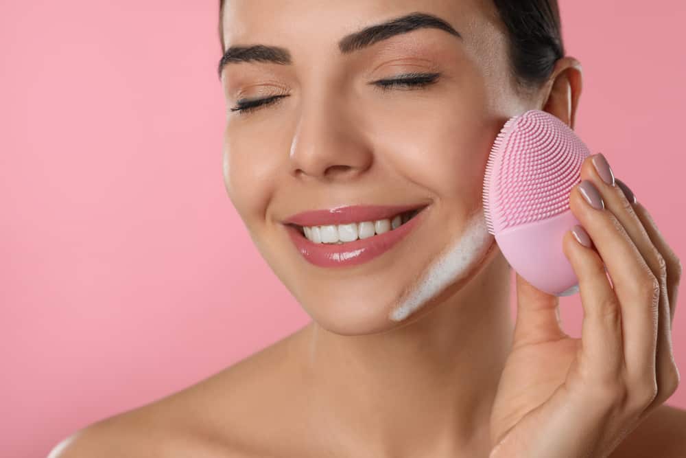 This is a close look at a woman using a facial silicon brush.