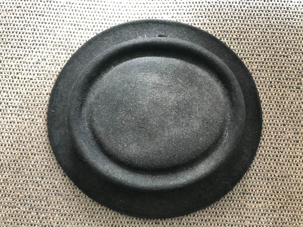 A close look at a charcoal black pork pie hat.