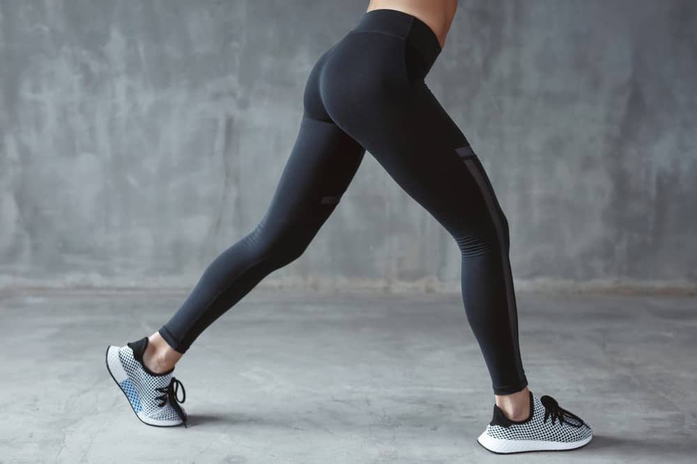 This is a close look at a woman wearing a pair of sporty black leggings.