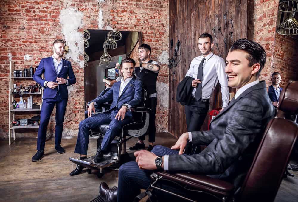 A group of men wearing suits inside the barbershop.