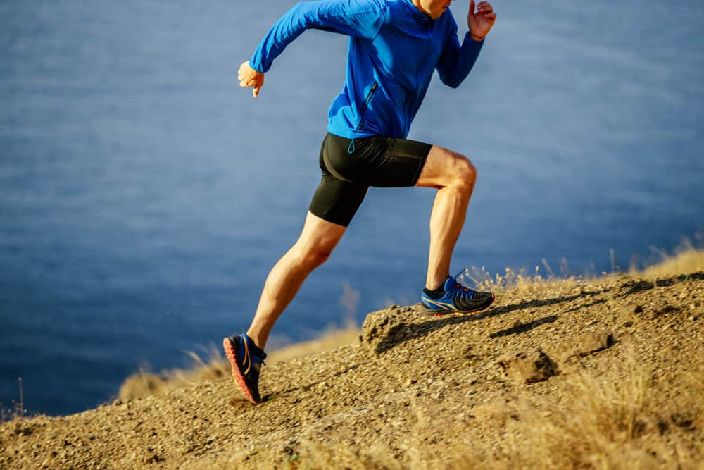 Man running on a steep slope of mountain.