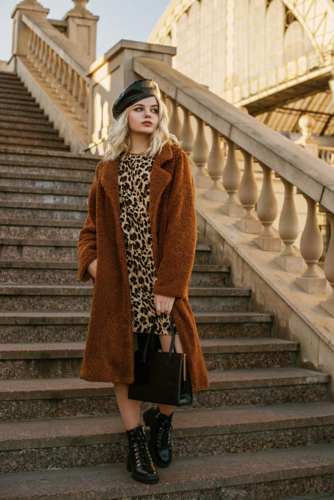 This is a woman wearing a leather beret with her animal print dress.