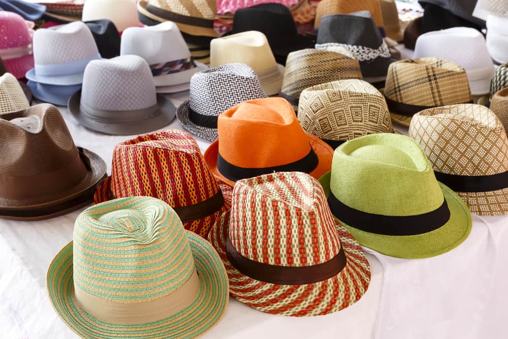 These are various colorful and patterned fedoras on display.