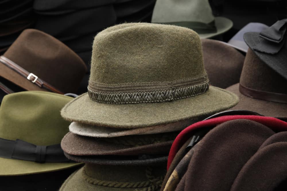 This is a close look at various fedora hats on display at a market.