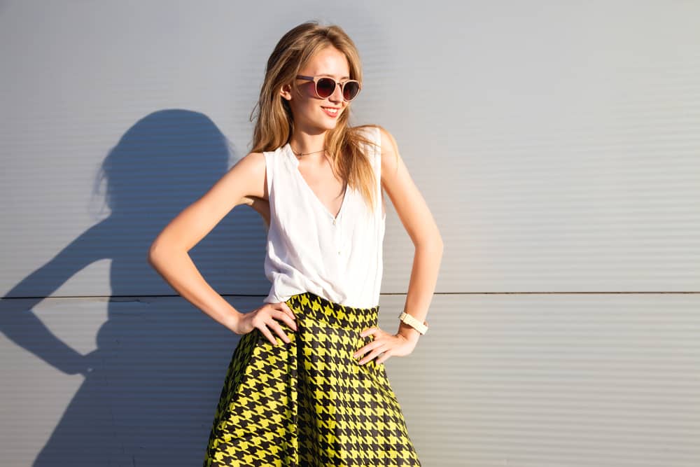 This is a woman wearing a white blouse with her patterned yellow skirt.