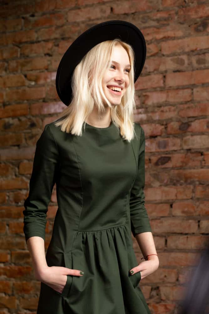A woman wearing a romper with her black fedora.