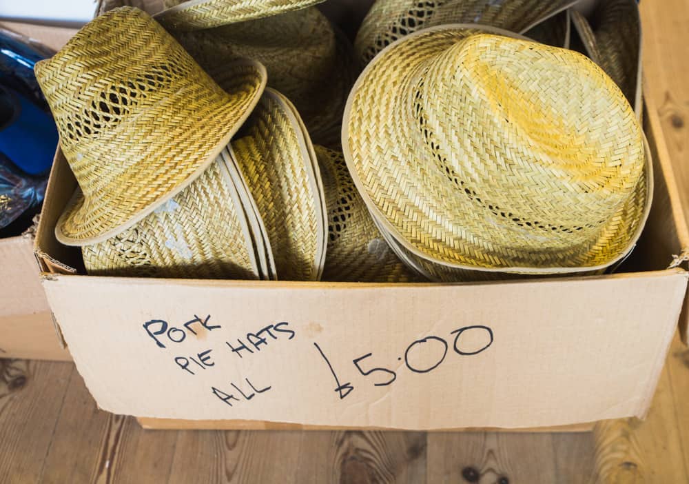 This is a box of woven pork pie hats for sale.