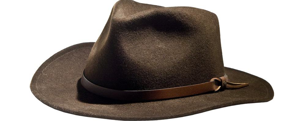 This is a close look at a felt fedora hat with a wider brim and a leather band.