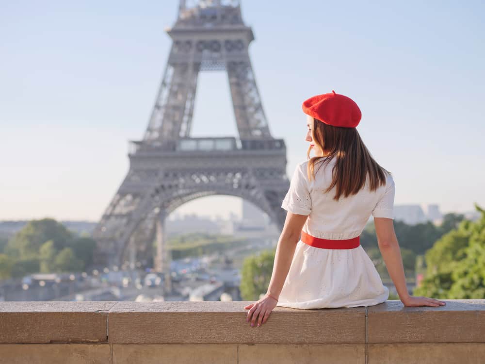 A woman wearing a red French beret with her dress.