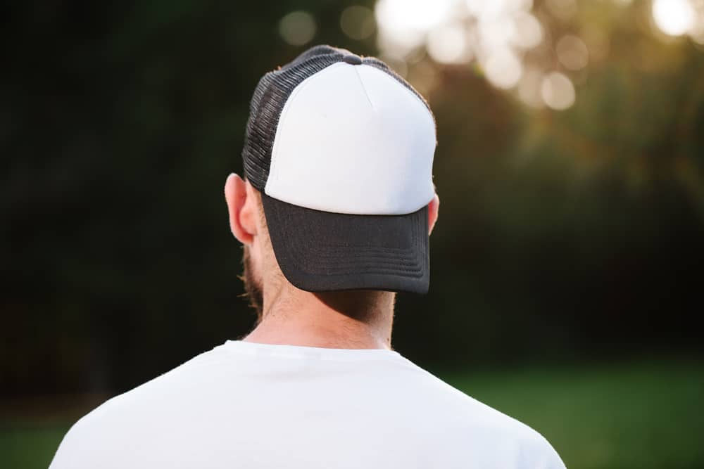 This is a close look at a man wearing a baseball cap backwards.